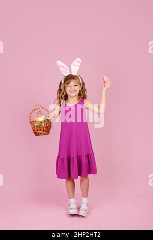 Happy kid showing decorated eggs and basket during Easter celebration Stock Photo