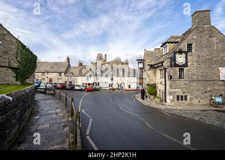 The Bankes Arms and Greyhound Inn pubs with ruins of Corfe Castle in background, on East Street in Corfe, Dorset, UK on 18 February 2022 Stock Photo