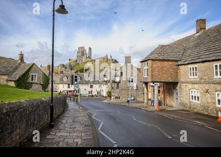 The Bankes Arms and Greyhound Inn pubs with ruins of Corfe Castle in background, on East Street in Corfe, Dorset, UK on 18 February 2022 Stock Photo