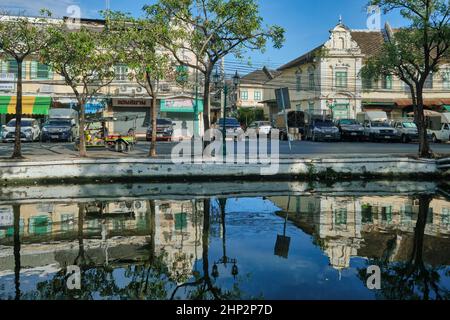 Picturesque old warehouses and shops lining Atsadang Road along Klong (canal) Lod in the of old city area of Bangkok, Thailand, reflected in the water Stock Photo