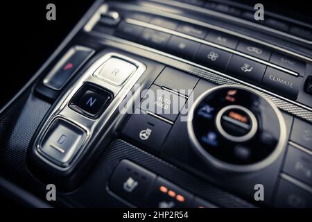 Close up shot of an automatic button gear shifter on a central console in a new car. Stock Photo
