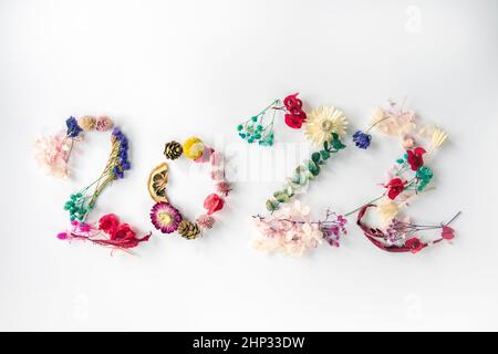 2022 number made from colorful fresh spring plants, flowers and leaves. Happy New Year concept isolated on white background. 2022 creative background, Stock Photo