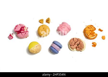 broken round macarons with crumbs on a white background, delicious dessert, top view Stock Photo