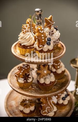 Christmas gingerbread cupcakes with creamy spiced frosting on the cake stand Stock Photo