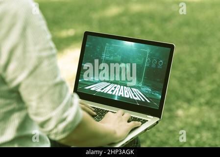 Hand writing sign Vulnerability, Business overview State of being exposed to the possibility of being attacked Woman Typing On Laptop Sitting Outside Stock Photo