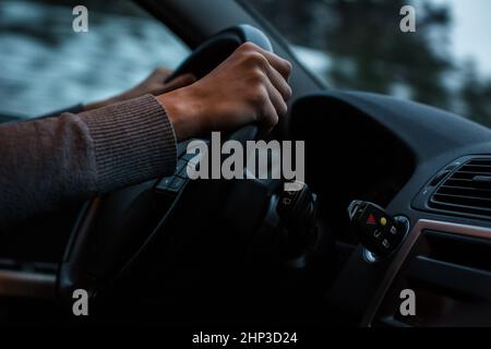 Driver's hands driving a car on a highway (color toned image; shallow DOF) Stock Photo