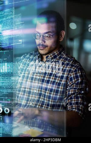 He writes in many programming languages. Cropped shot of a young computer programmer looking through data. Stock Photo
