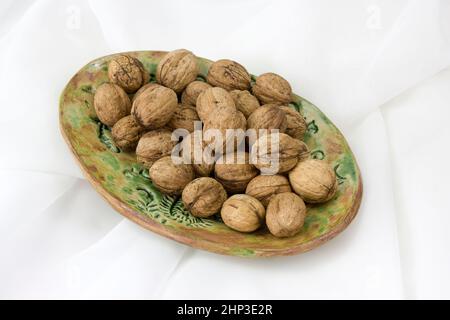 walnuts on a clay plate - white background Stock Photo