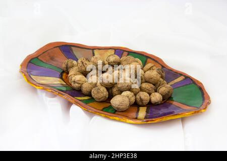 walnuts on a clay plate - white background Stock Photo