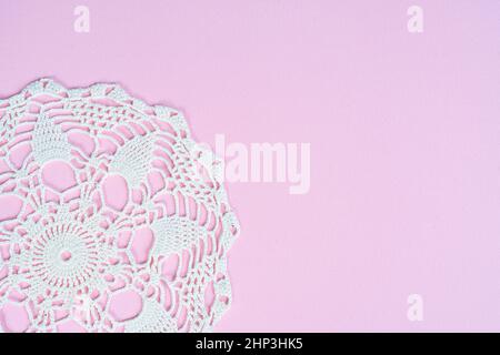 A white crochet embroidered doily on a blue surface Stock Photo
