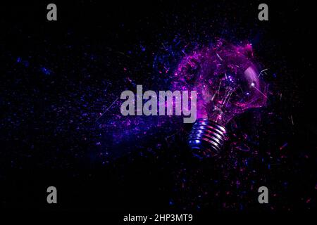 explosion of an electric light bulb on black. purple and blue light. Stock Photo