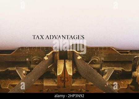 Closeup on vintage typewriter. Front focus on letters making TAX ADVANTAGES text. Business concept image with retro office tool. Stock Photo