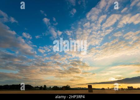 Altocumulus clouds give an attractive sunset over a field of harvested cereal crop in West Yorkshire Stock Photo