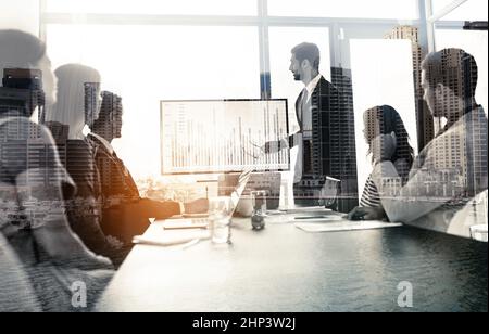 Big city business. Multiple exposure shot of businesspeople in a meeting superimposed on a cityscape. Stock Photo