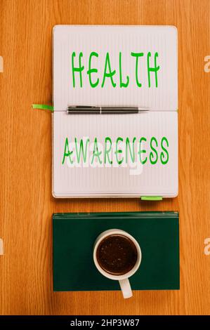 Hand writing sign Health Awareness, Internet Concept Promoting community issues and preventative action Plain Blank Notebooks And A Pen Beside A Cup O Stock Photo