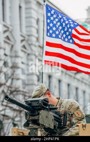 United States Marine Corps soldier on the top of a military vehicle mounting a machine gun with American flag, USA or US army ready for war Stock Photo