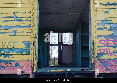 Old abandoned train carriage, peeling paint from the wooden wall Stock Photo