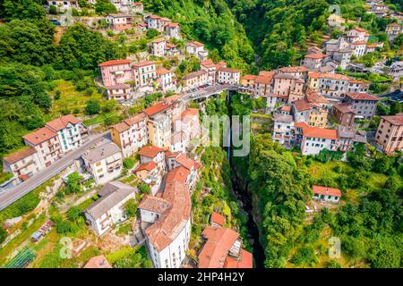 Town of Nesso on steep cliffs and creek waterfall gorge on Como Lake aerial view, Lombardy region of Italy Stock Photo