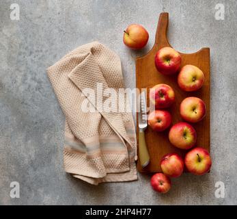 Red ripe apples on wooden board on gray stone table, top view Stock Photo