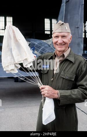 Retired COL Gail S. Halvorsen displays a parachute similar to the ones he used during the Berlin Airlift, when he acquired the nickname of the 'Rosinen (raisin) Bomber' for his practice of dropping candy to children who were lined up to watch aircraft landing at Tempelhof, West Berlin, 6/23/1988. Stock Photo