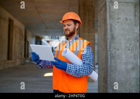 Contractor using digital tablet for connection with engineer. Builder reporting having video call Stock Photo