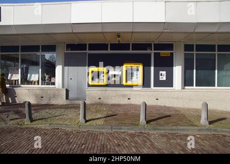 Cashpoint (ATM, cash dispenser, cash machine) called Geldmaat for all Dutch banks (ABN AMRO, ING, Rabobank) with a yellow border in the village Stock Photo