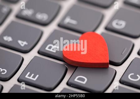 Small red heart on computer keyboard. Internet dating concept. Stock Photo