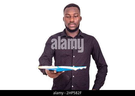 a handsome young man in a long sleeve shirt holding documents. Stock Photo