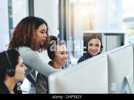 We might have found the perfect solution. Shot of a young woman assisting her colleagues in a call centre. Stock Photo