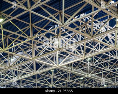 Beam metal structures with spotlights on a blue ceiling in large building Stock Photo