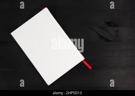 White book with copy space on dark wooden background Stock Photo