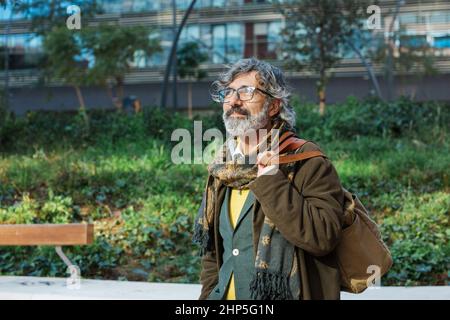 Middle-aged businessman looking away while standing outdoors in the financial district of the city. Stock Photo