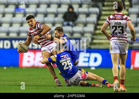 Kai Pearce-Paul #21 of Wigan Warriors is tackled by James Donaldson #25 and Aidan Sezer #7 of Leeds Rhinos Stock Photo