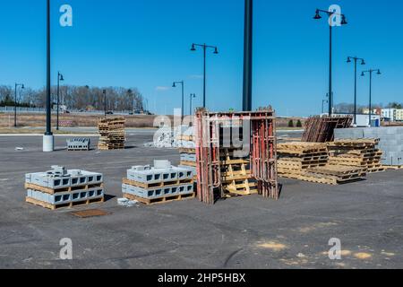 Horizontal shot of cinder blocks, scaffolding, and wooden pallets at an industrial construction site.