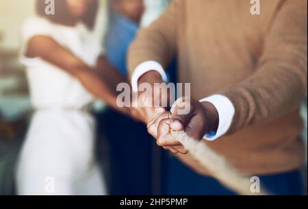 Never give up, great things take time. Cropped shot of corporate businesspeople pulling on a rope during tug of war. Stock Photo