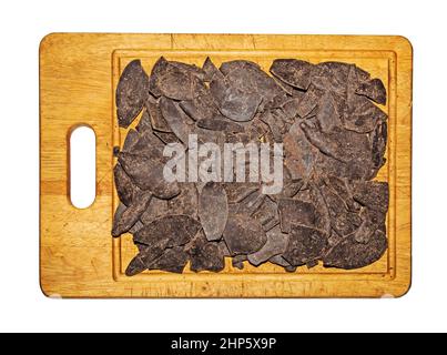 Grated cocoa chocolate ingredient on a wooden board. Chunks of cocoa liquor before grinding. Isolate. Stock Photo