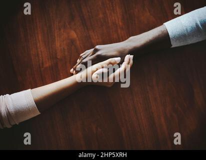 Reaching out in support. High angle shot of two people holding hands in comfort. Stock Photo