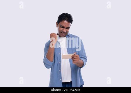 Indian Man Excited Winning. Man Holding Phone. Winner. Man Won online Casino, Lottery Stock Photo