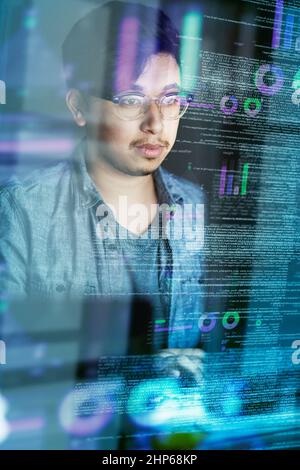 Writing code is what he does. Cropped shot of a young computer programmer looking through data. Stock Photo