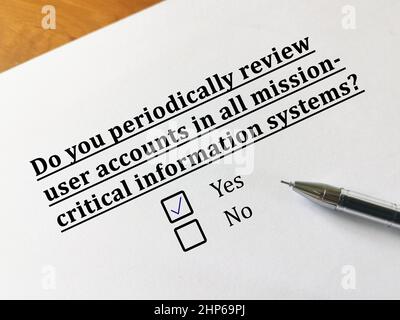 One person is answering question about cybersecurity. The person periodically reviews user accounts in all mission critical information system. Stock Photo