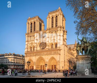 Paris, France - April 15, 2015: View of Notre-Dame Cathedral in sunset sunrays. Unidentified people present on picture. Stock Photo