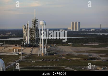 A Falcon 9 rocket stands ready for liftoff at the Kennedy Space Center's Launch Complex 39A. In this aerial view, stands on the launch pad with the Vehicle Assembly Building (VAB) in the background. To the right of the VAB is the mobile launcher that will be used for stacking NASA's Space Launch System rocket which will send the agency's Orion spacecraft on missions beyond low-Earth orbit. The Falcon 9 will boost a Dragon resupply spacecraft to the International Space Station. Liftoff is scheduled for 9:39 a.m. EST. Dragon will bring up 5,500 pounds of supplies, on its 10th commercial resupply Stock Photo