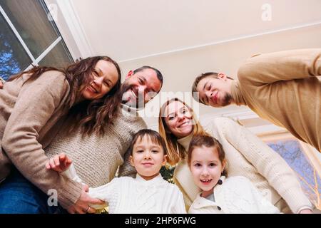 View from bottom of happy large caucasian family with many children making selfie photo at home, parents with kids looking at camera and having fun wh Stock Photo