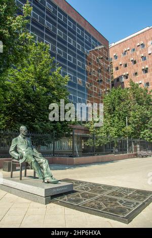 Statue of Swiss-French architect Charles-Edouard Jeannere Le Corbusier in front of the massive red Tsentrosoyuz or Centrosoyuz Building in Moscow Stock Photo
