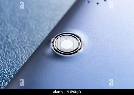 Tablet camera lens close up. Digital device. Macro shot. On blue background Stock Photo