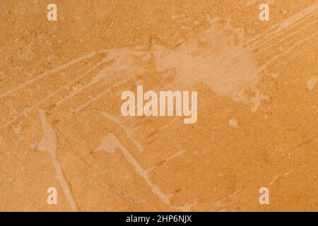 Smudges on a pressed brown rough paper. Distressed cardboard parchment. Abstract background. Dirty brush stroke close up. Copy space Stock Photo
