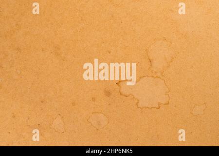 Smudges on a pressed brown rough paper. Distressed cardboard parchment. Abstract background Stock Photo
