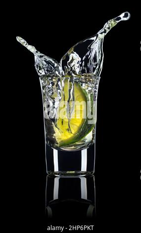 shot of vodka or tequila with lime slice and splash Stock Photo