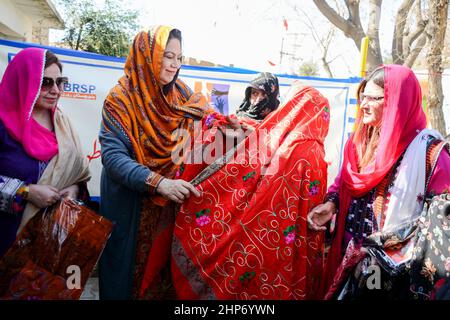 HARNAI-PAKISTAN, Feb 18-2022: Chairperson national commission on the status of women Mrs. Nelofer Bakhtiar wearing a chador (traditional scarp) to earthquake effected women during the relief distribution in Harnai District. Stock Photo