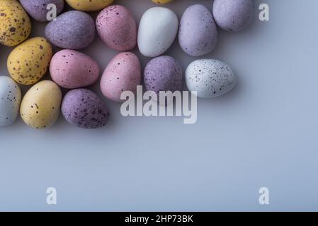 Colorful speckled mini Easter eggs on a plain back ground shot from above, flat lay Stock Photo